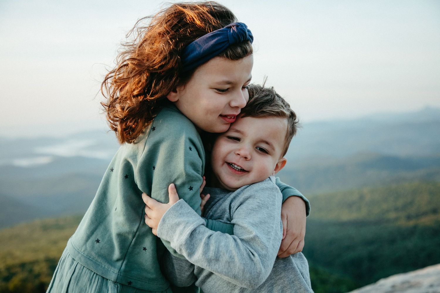 Tender moment between two people hugging with mountains in background.