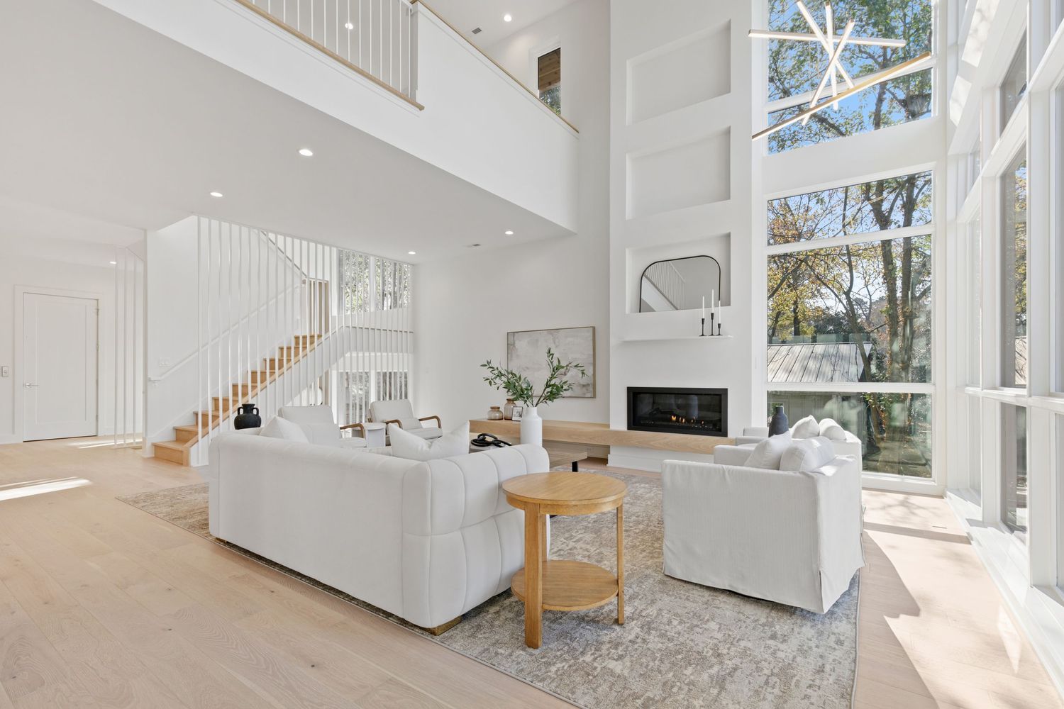 Open concept interior featuring high ceilings, large windows, and white walls creating a bright, spacious atmosphere.