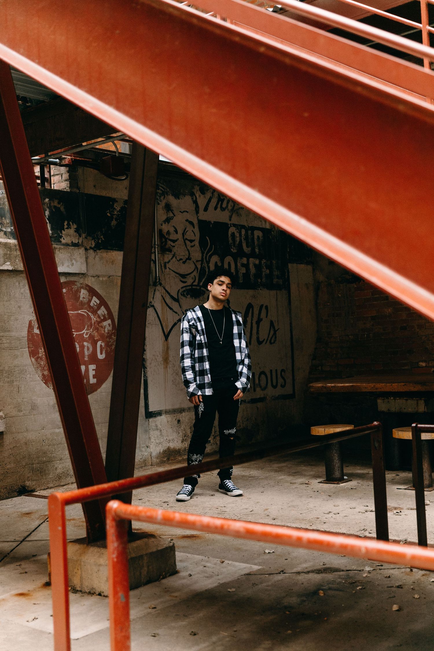 Urban scene with black and white checkered patterns against concrete walls and orange metal beams.