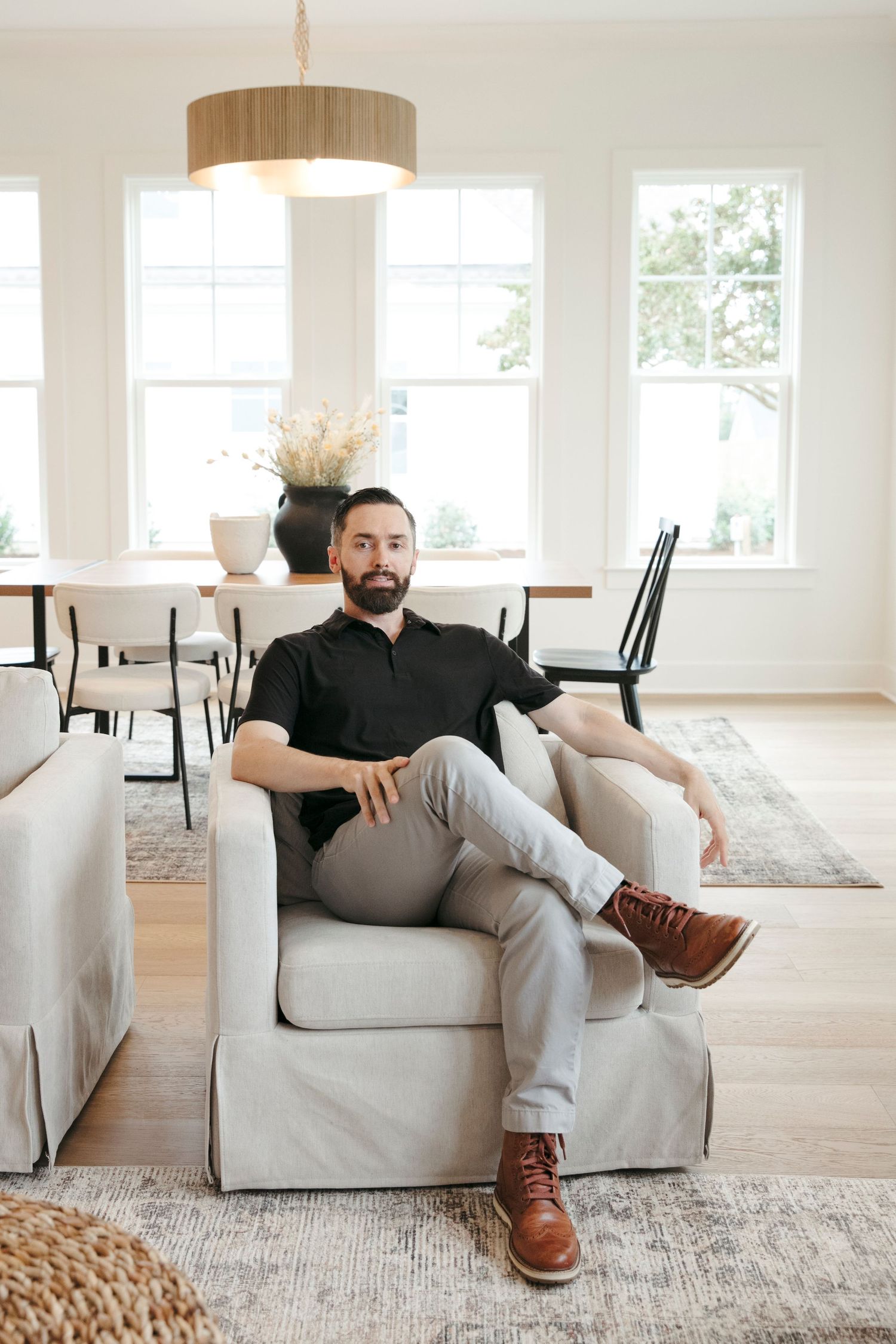 Interior lifestyle photo of someone relaxing in a bright modern living room with hardwood floors.
