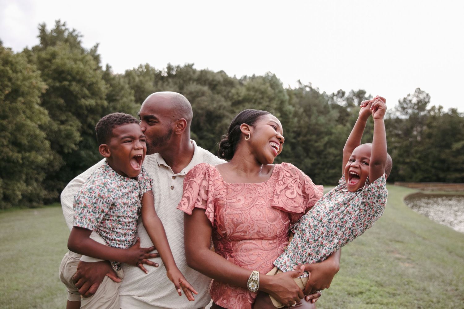 Family shares joyful laughter while playing together outdoors.