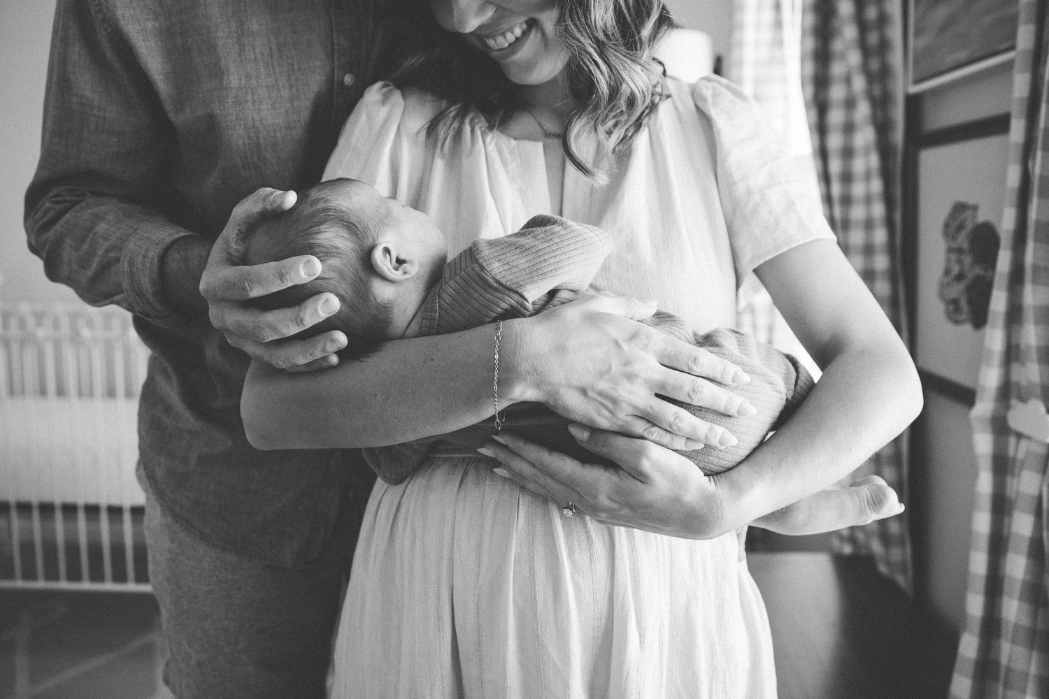 A series of black and white photos showing tender moments between parents and their baby during a lifestyle photo session.