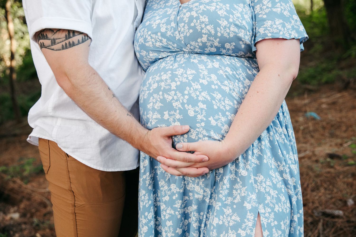 Close-up of couple holding ultrasound photos during maternity photoshoot.