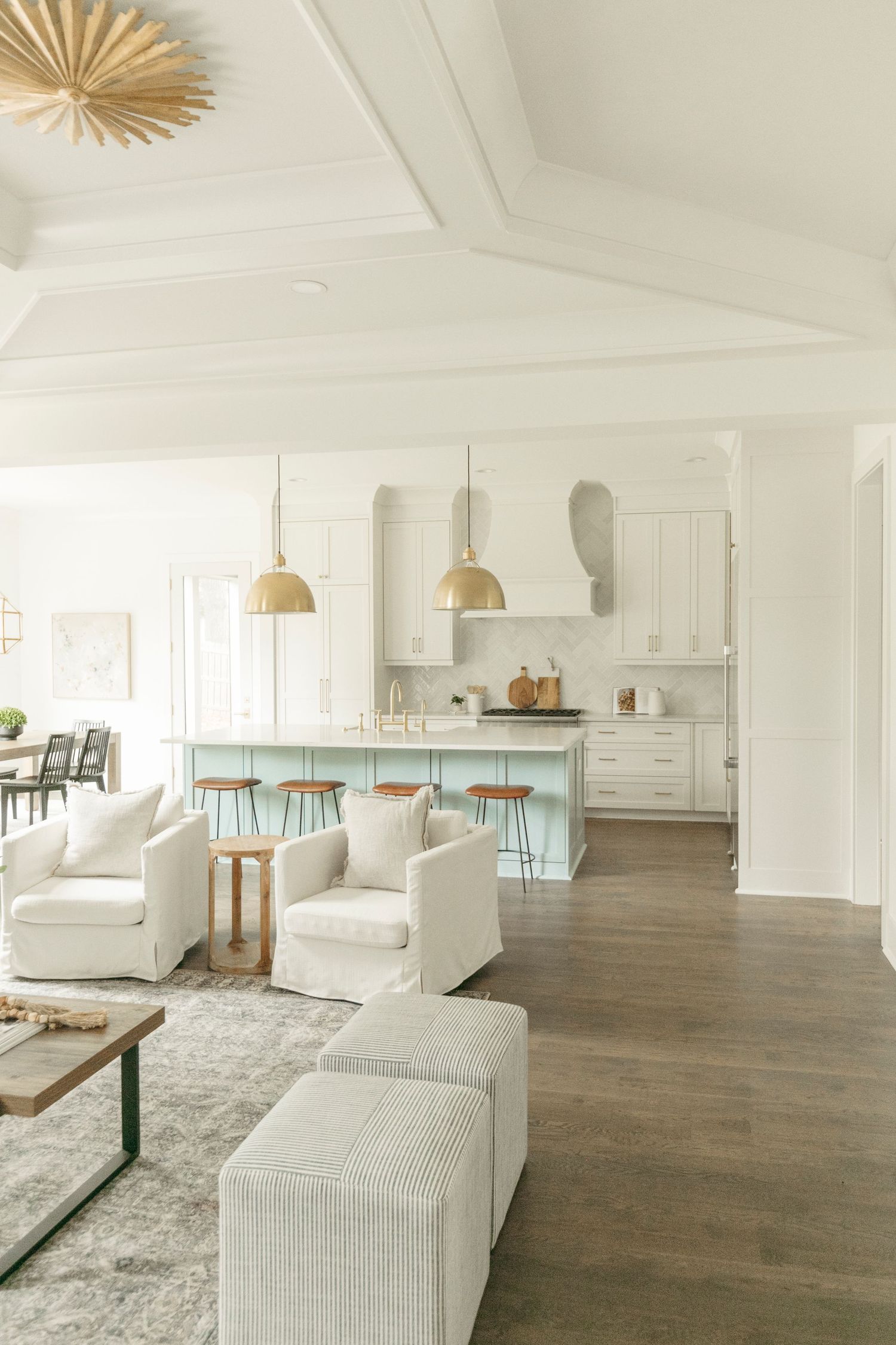 Airy open concept living and kitchen space with coastal decor and white upholstered furniture.