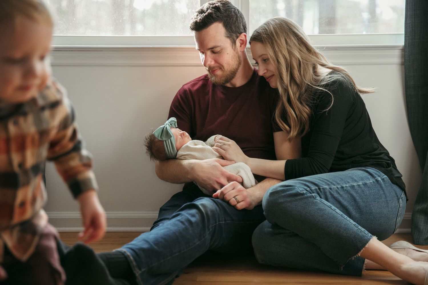 A tender family moment on the floor as they gather around their newborn.