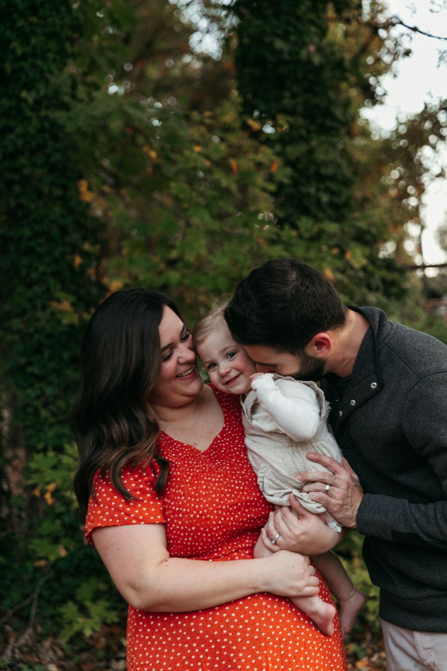 Family sharing joyful moment together outdoors with small child.