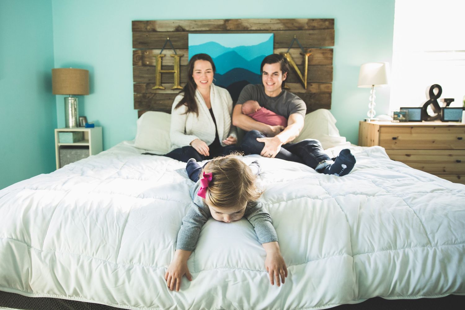 A sequence of photos showing someone lying down and rolling across a white bed with turquoise walls in the background.