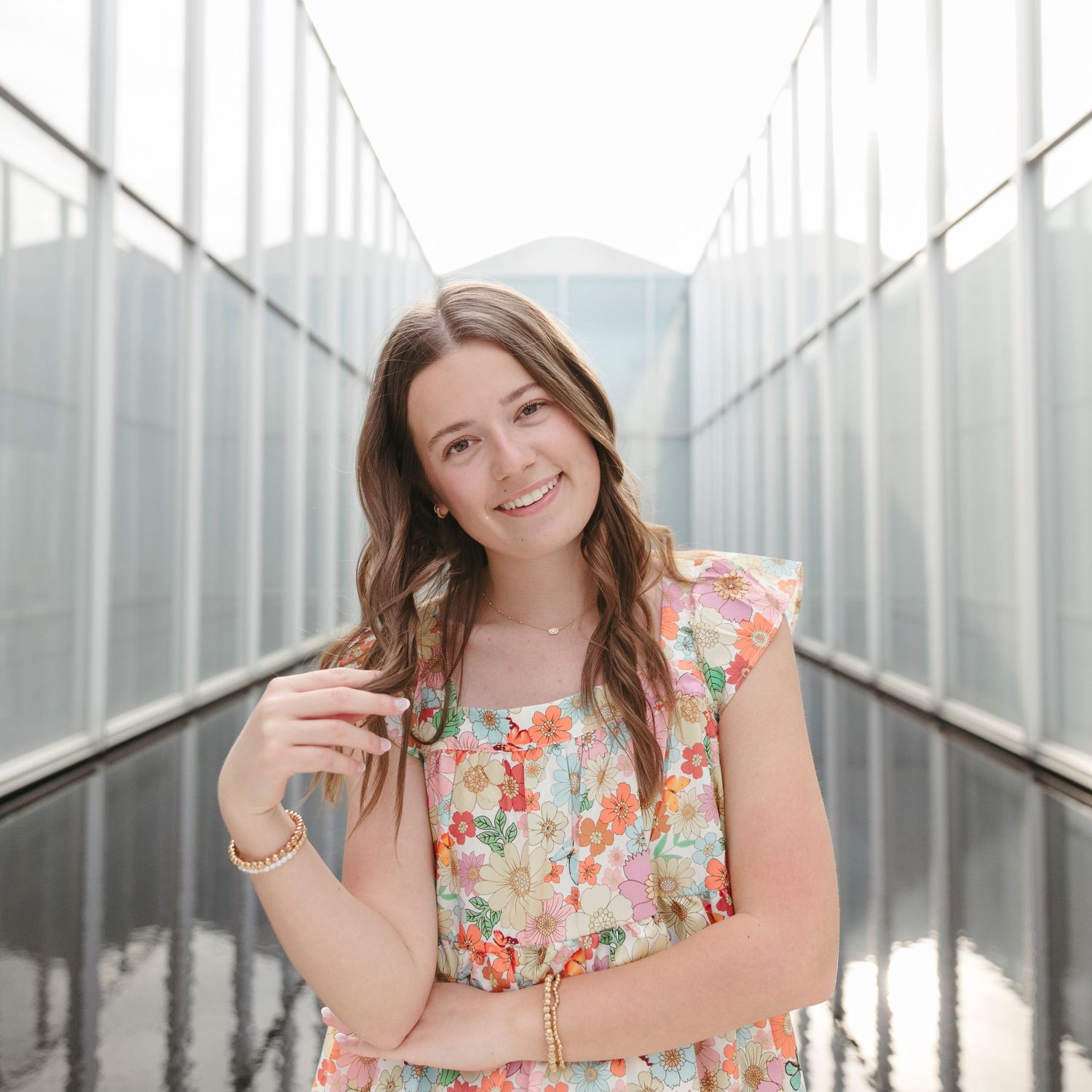 Cheerful portrait sequence of someone in a floral top against industrial metal backdrop.