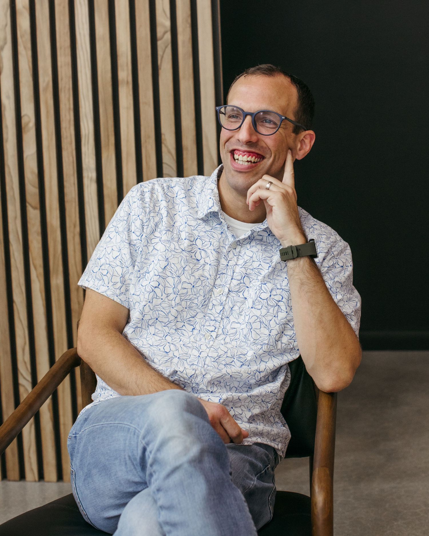 Contemporary portrait series showing relaxed poses against wooden slat wall background.