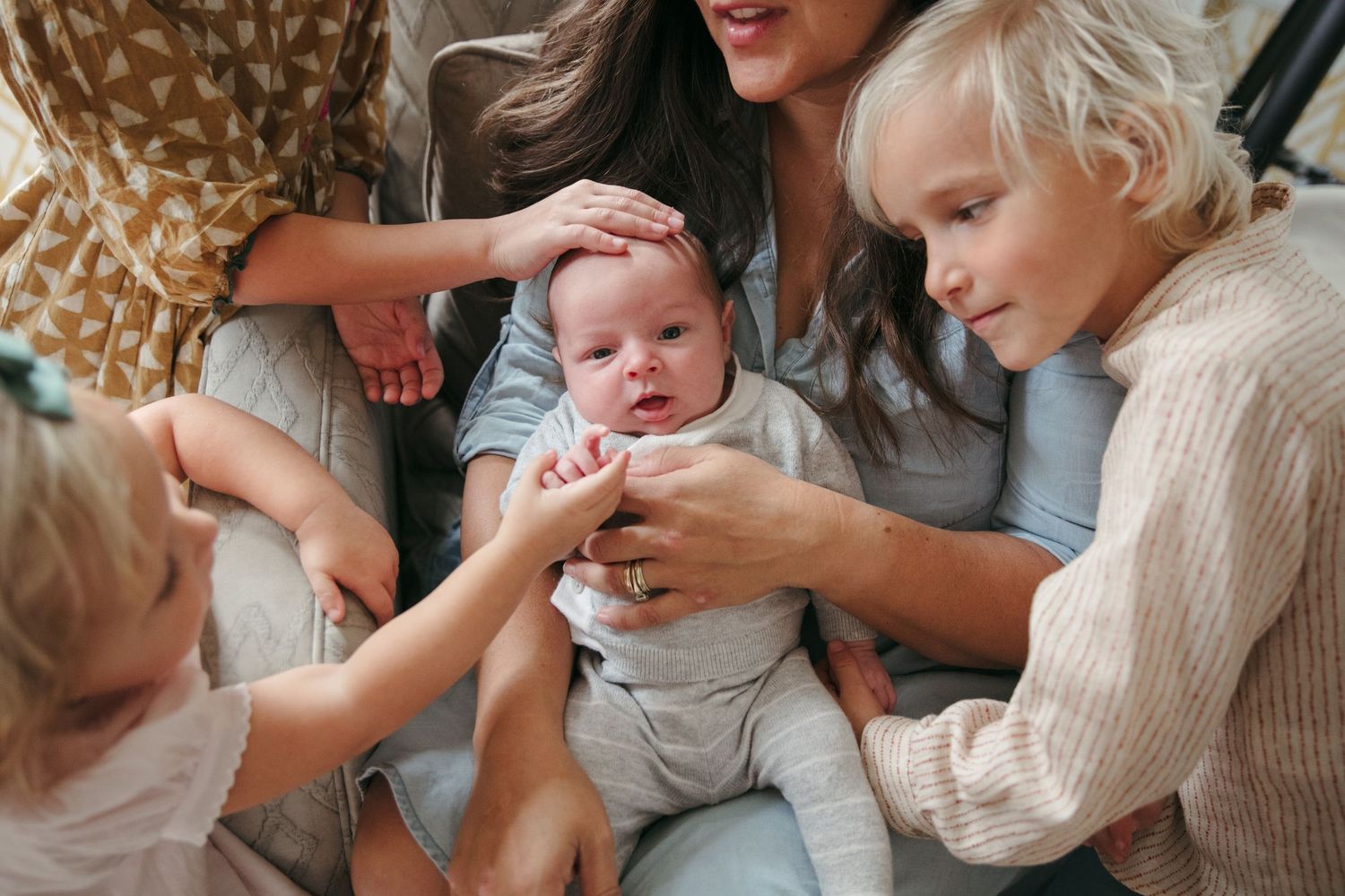 Tender family moment showing gentle interactions with a newborn in soft natural lighting.