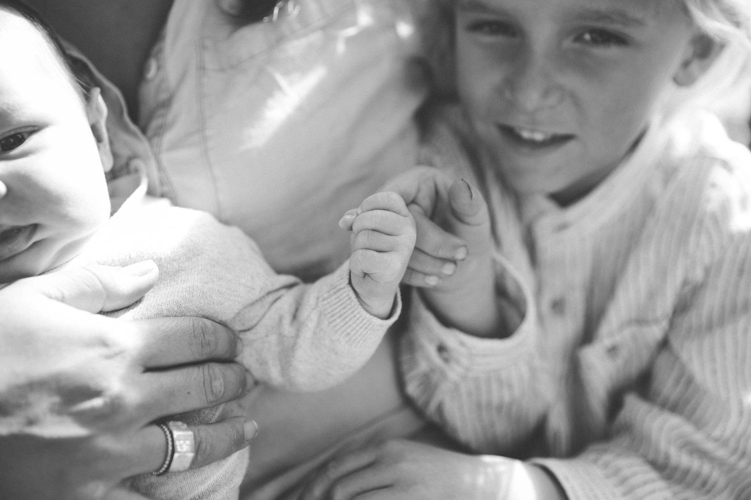 Black and white photo series capturing intimate moments of parent-child interaction in a crib.