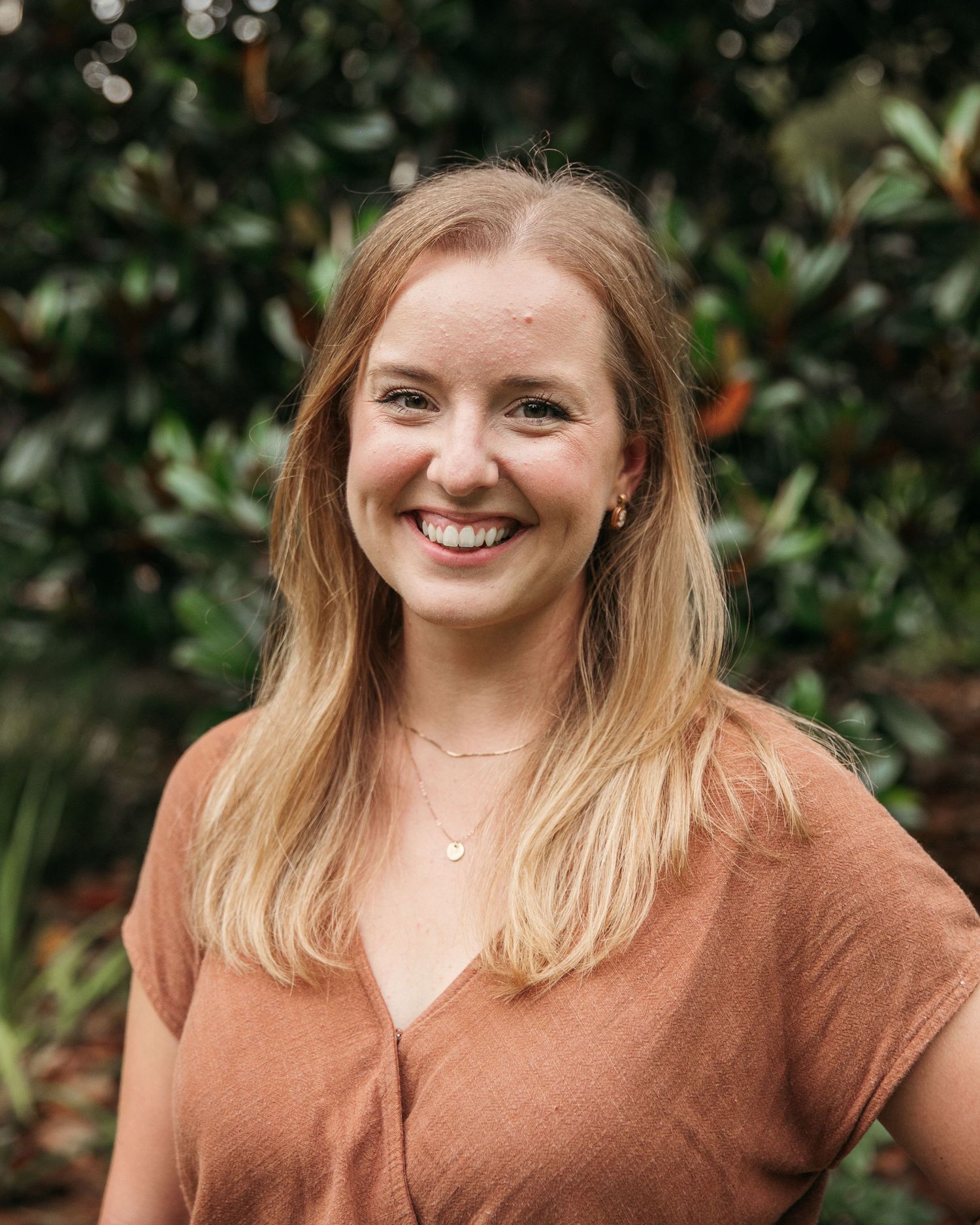 Outdoor portrait sequence showing someone in a brown top against a dark green leafy background.