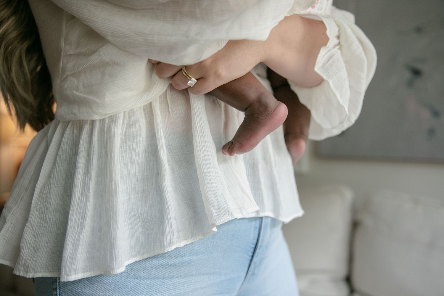 Close-up detail of white ruffled shirt and light denim in soft lighting.