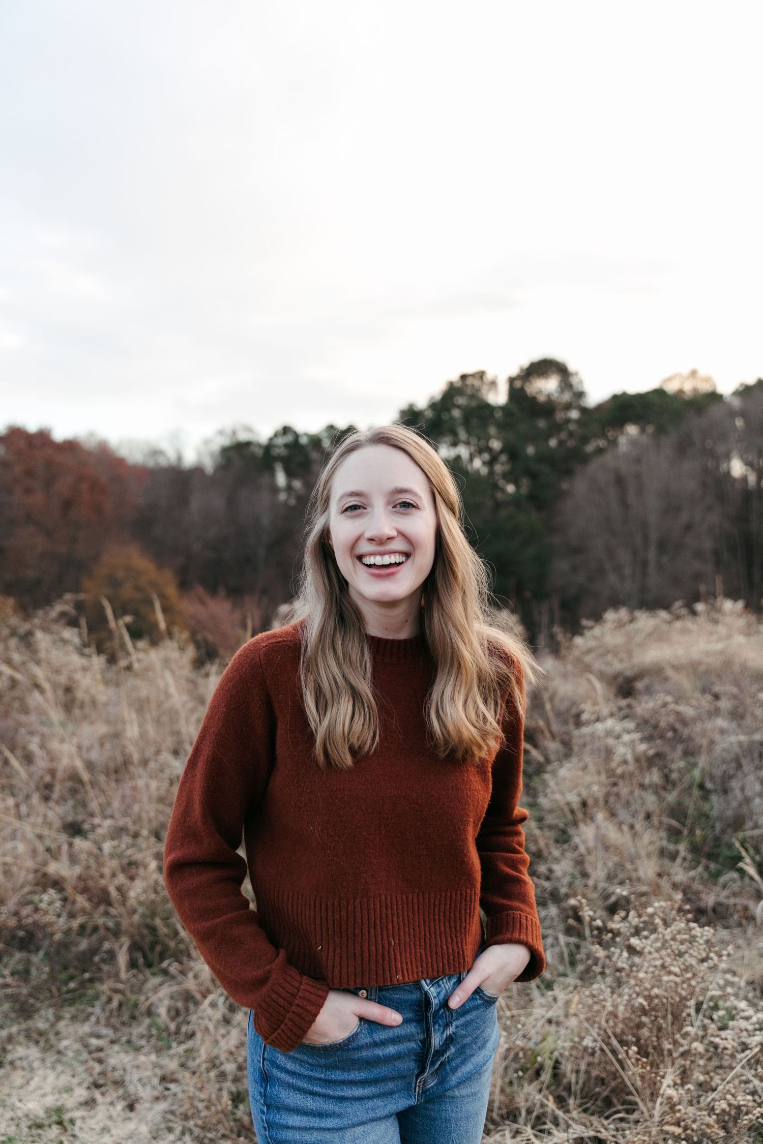 Casual outdoor portrait session in fall field setting with natural lighting.