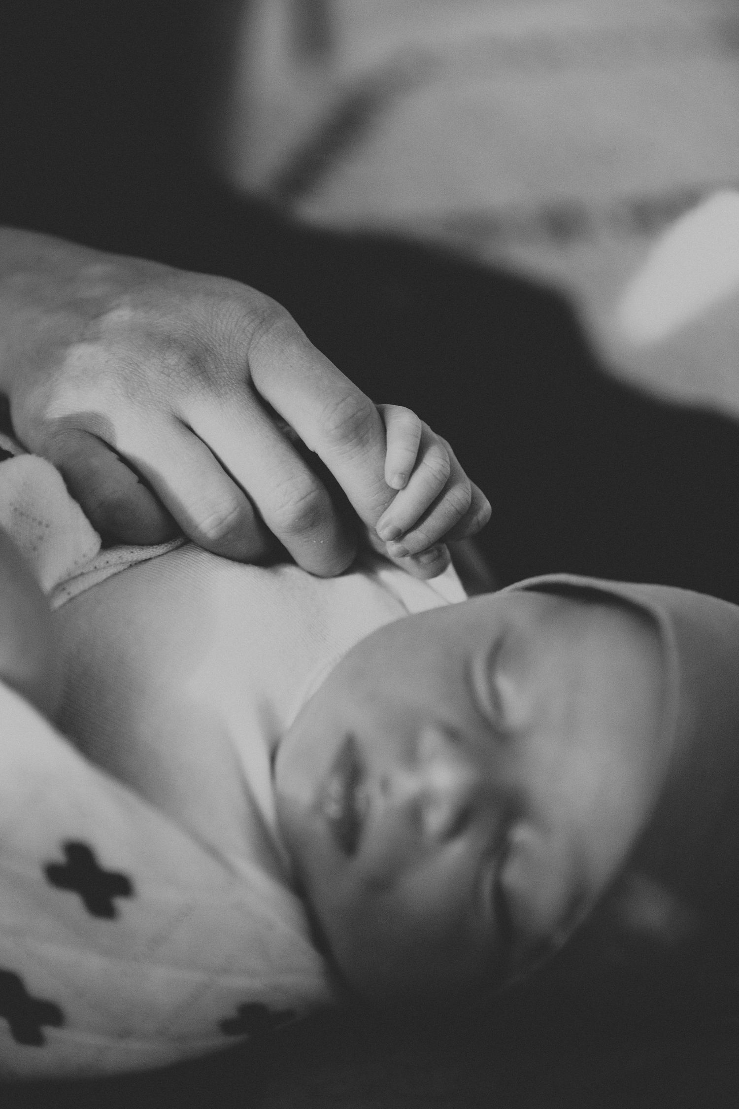 A gentle black and white portrait of a sleeping newborn baby's face.