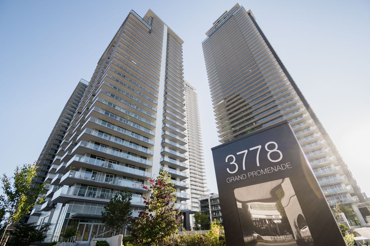 Twin residential towers at 3778 Grand Promenade sign on a sunny day with blue skies.