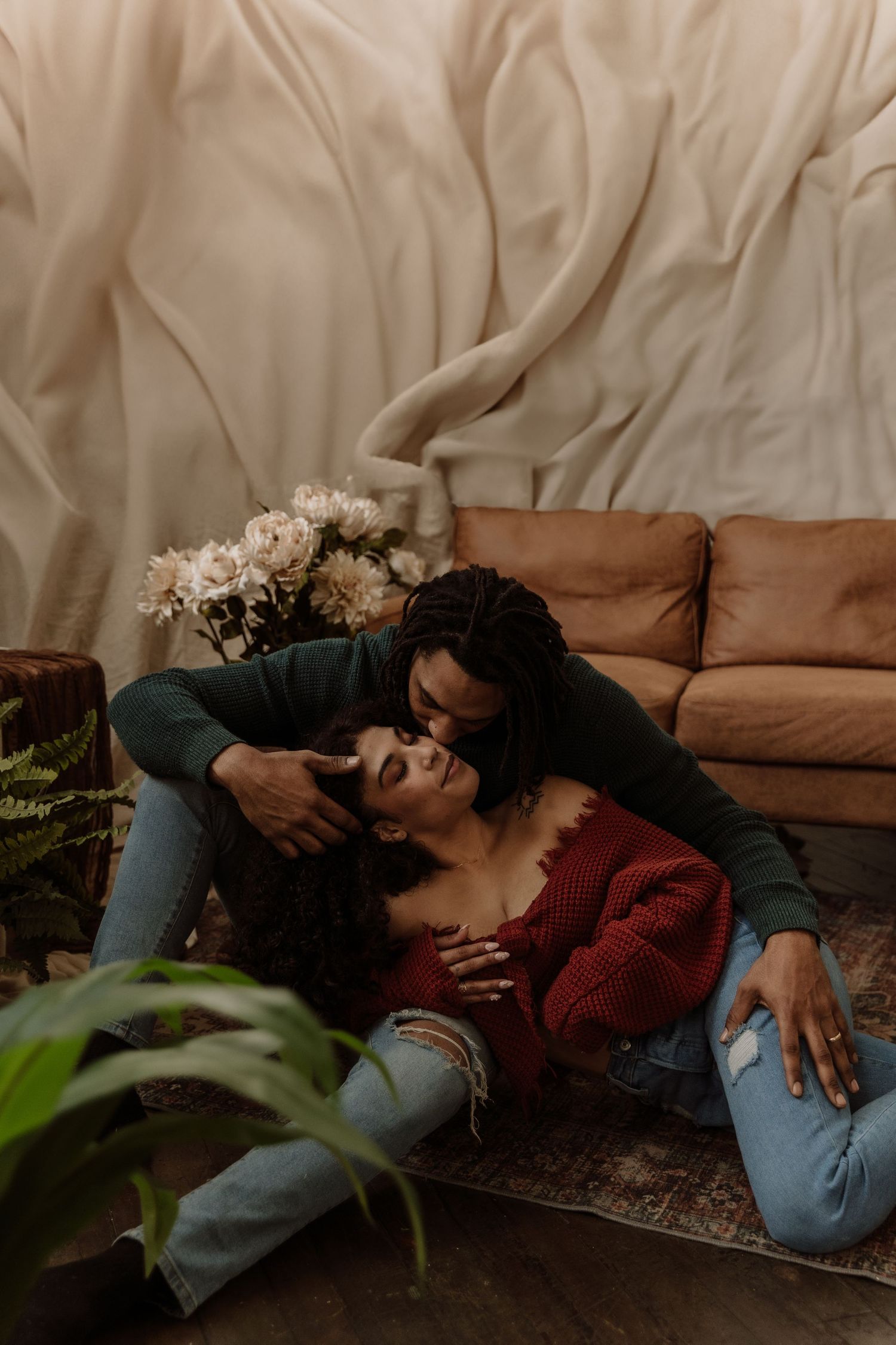 Cozy indoor couple portrait with romantic lighting and soft textures.