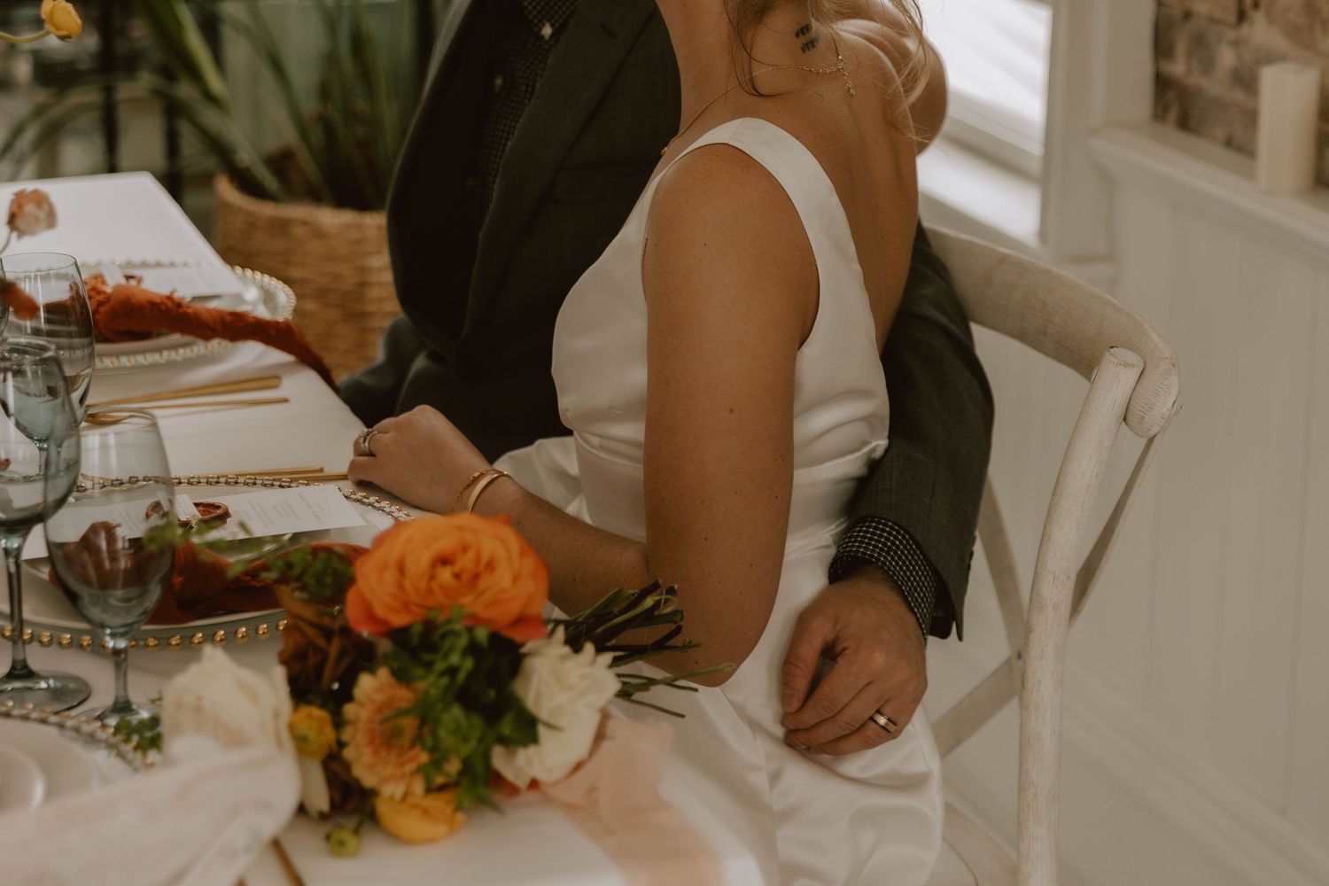 Elegant table setting with orange floral centerpiece and intimate dining atmosphere.