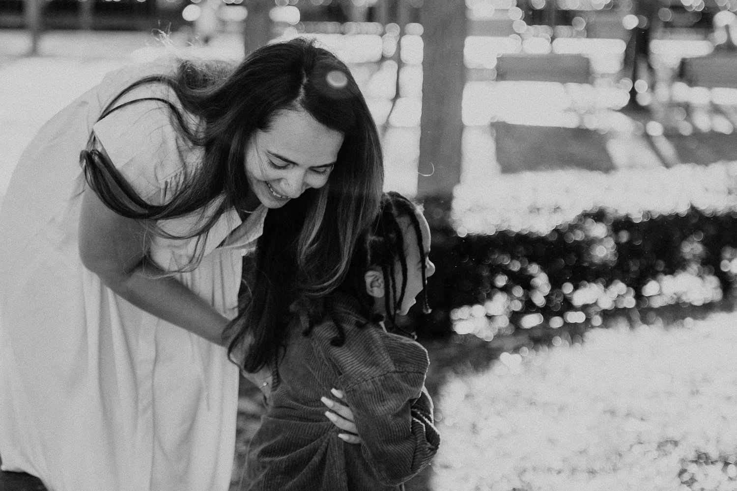 Joyful black and white portrait of person embracing a happy dog outdoors.