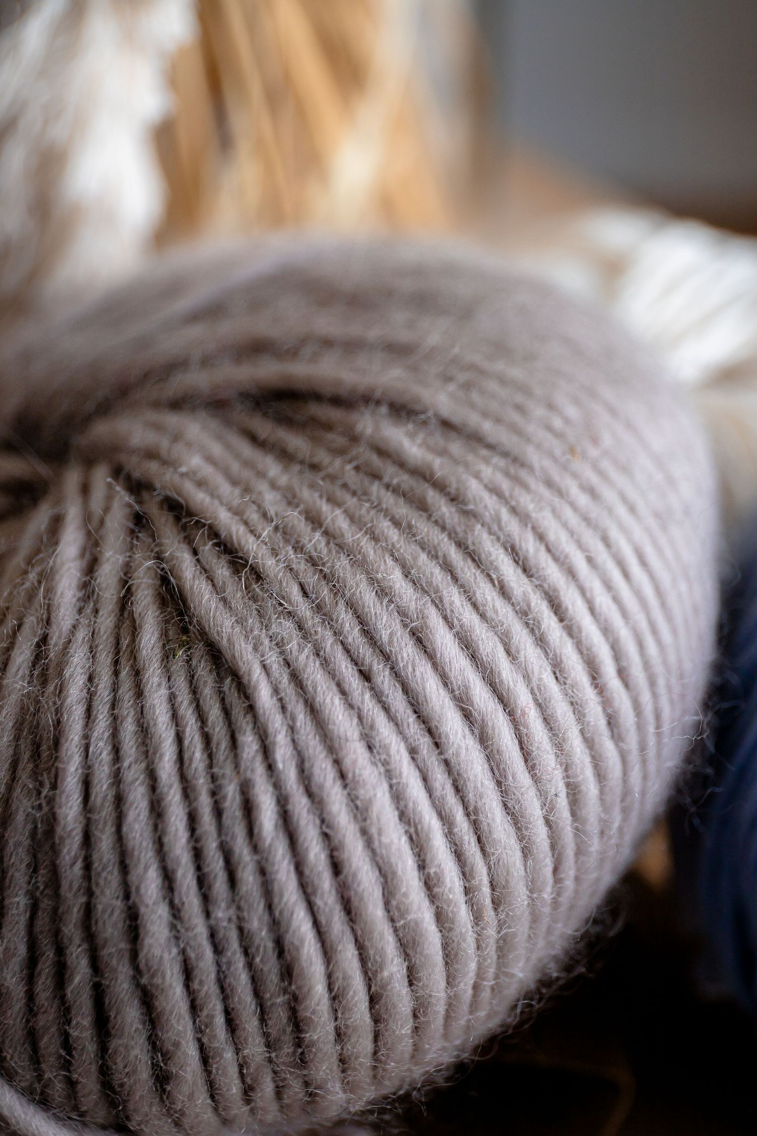 Close-up macro shot of ribbed knit texture in beige wool yarn.