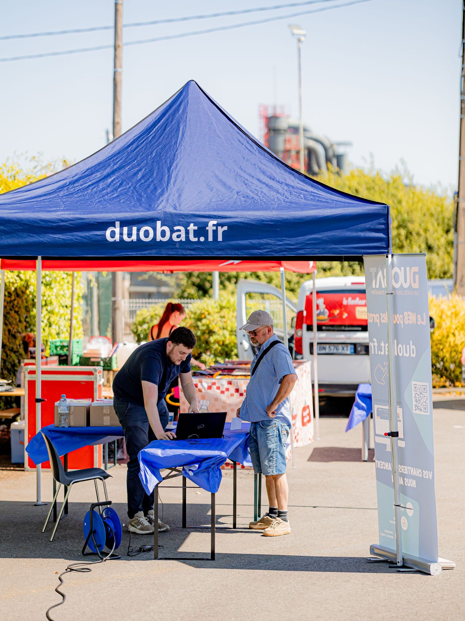 Blue Duobat branded tent canopy at an outdoor event with table setup.