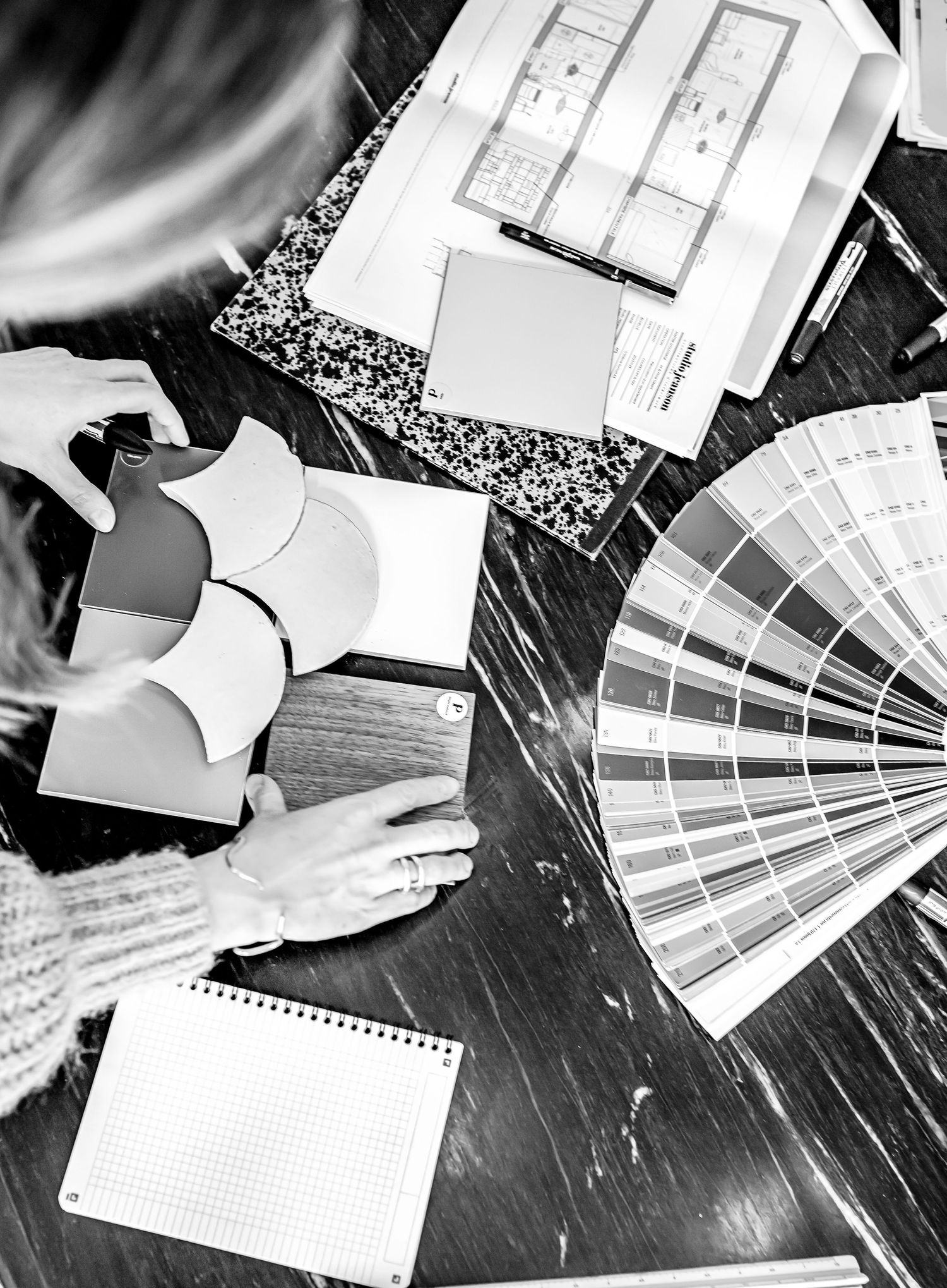 Overhead view of design materials including color swatches and architectural drawings.