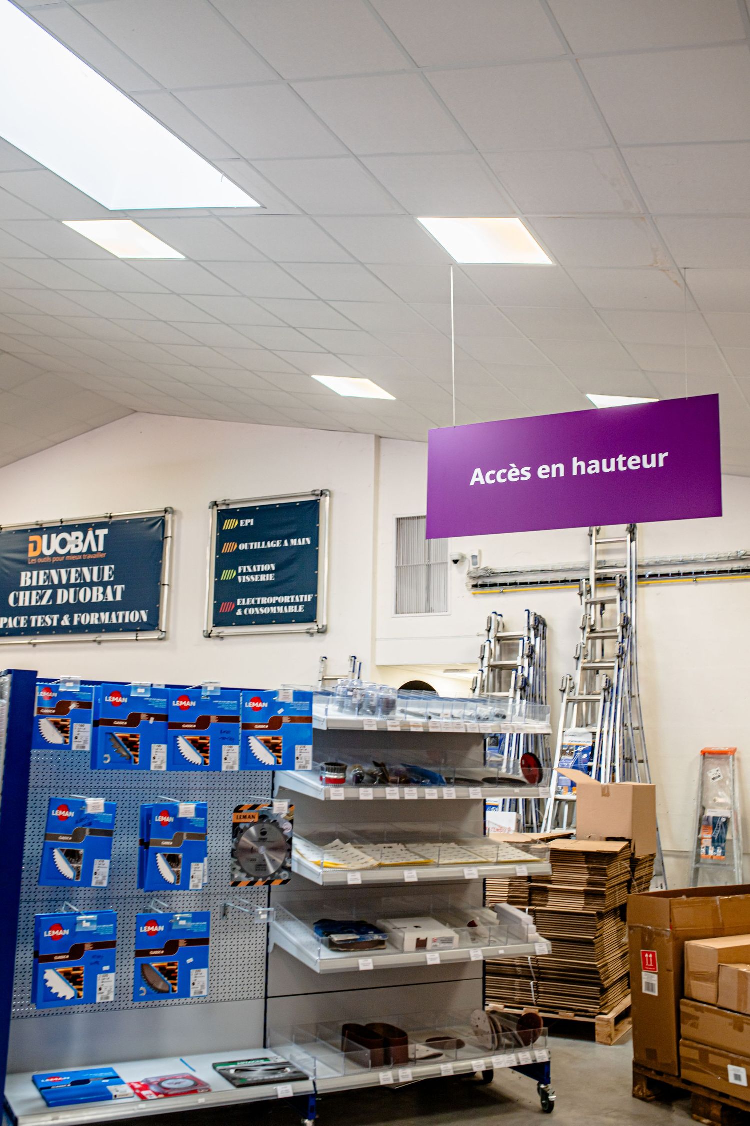 Store interior with purple signage and shelving displaying hardware and construction supplies.