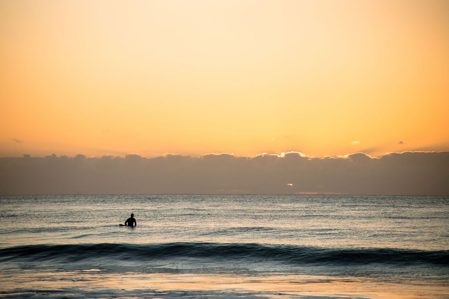 Surfeur au coucher de soleil attendant la vague