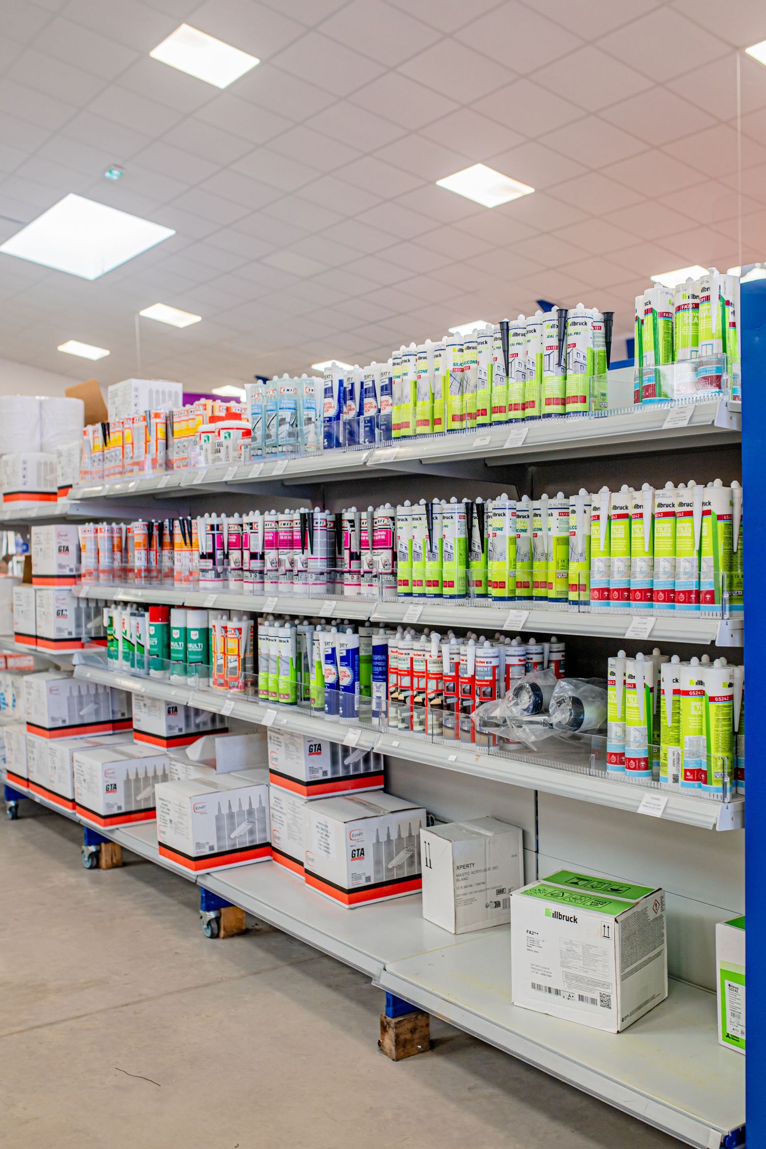 Retail shelves stocked with various cleaning supplies and maintenance products in a warehouse store.