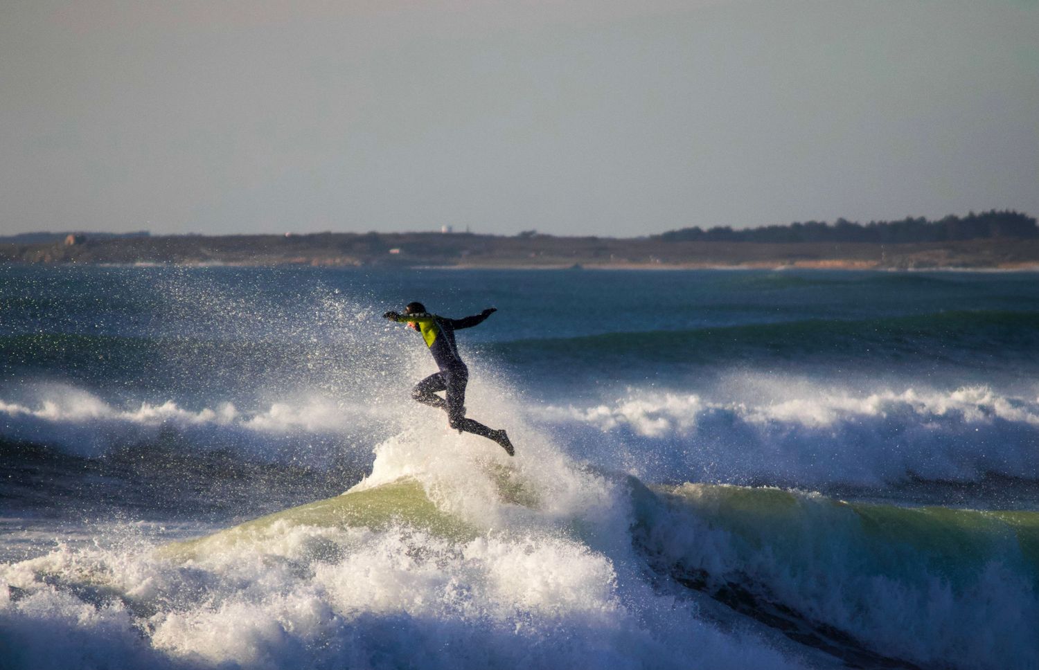 Action sequence of surfer catching waves and performing aerial maneuvers in ocean waves.