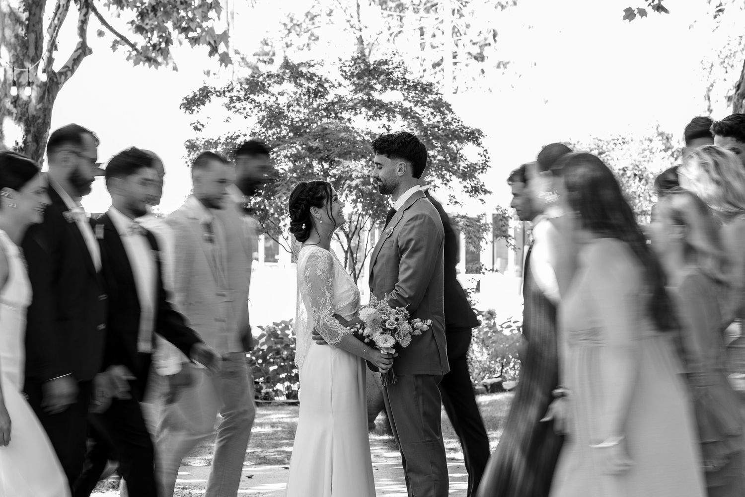 A black and white photo collage showing wedding guests gathering and mingling at an outdoor celebration.