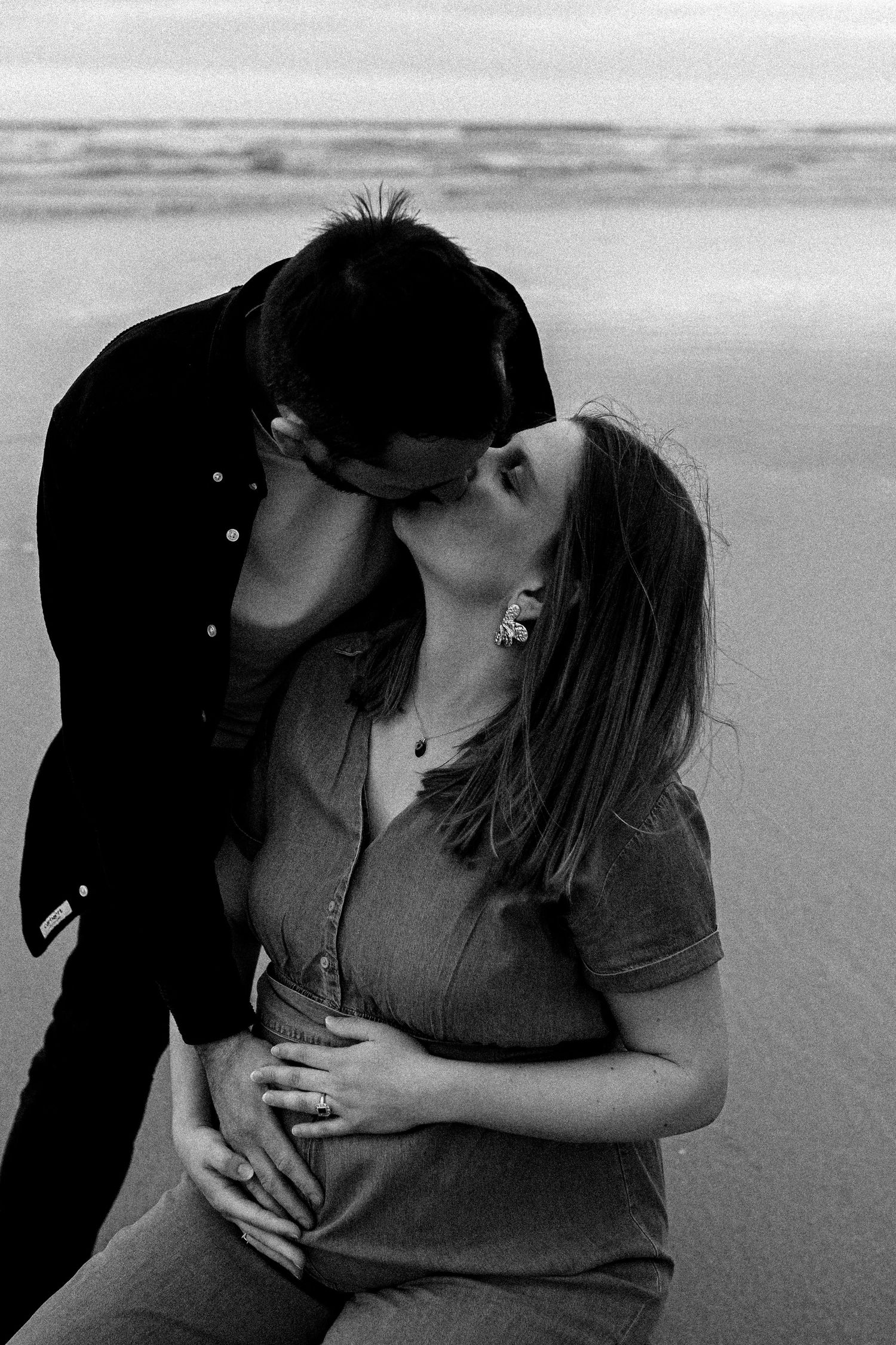 détail bisous couple grossesse bord de mer