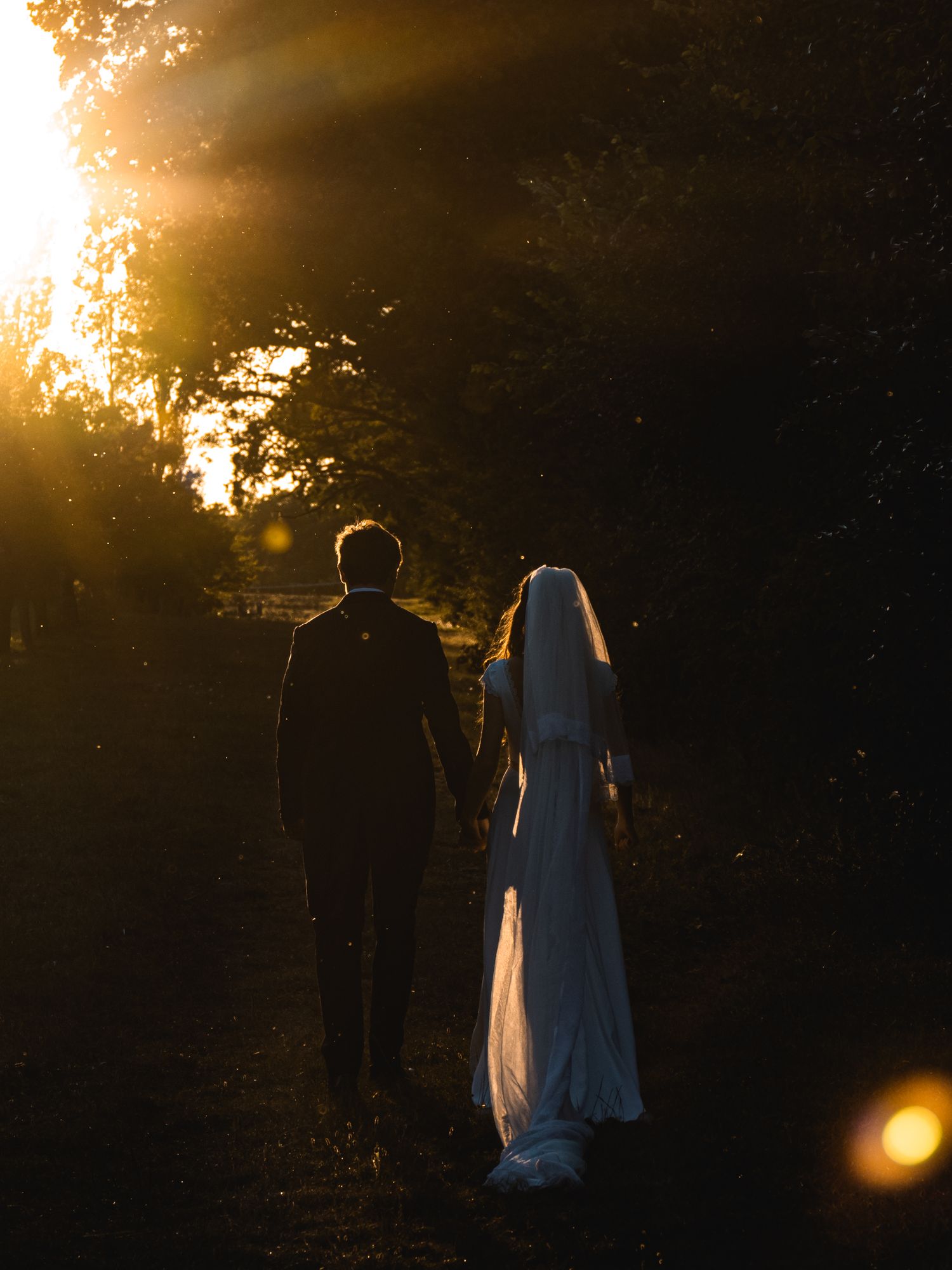 photo de couple mariés contre jour golden hour