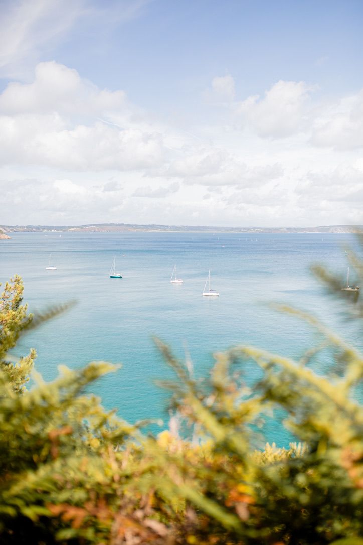 Tropical seascape with turquoise waters and boats against cloudy sky.