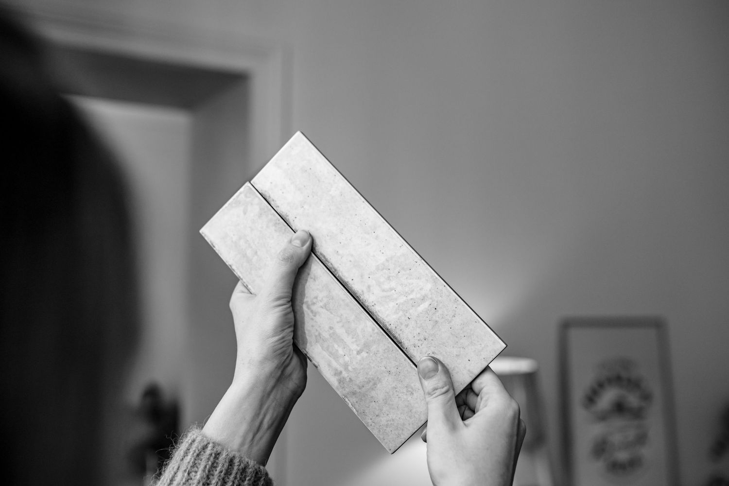 Hand holding a white paper envelope against a blurred background.