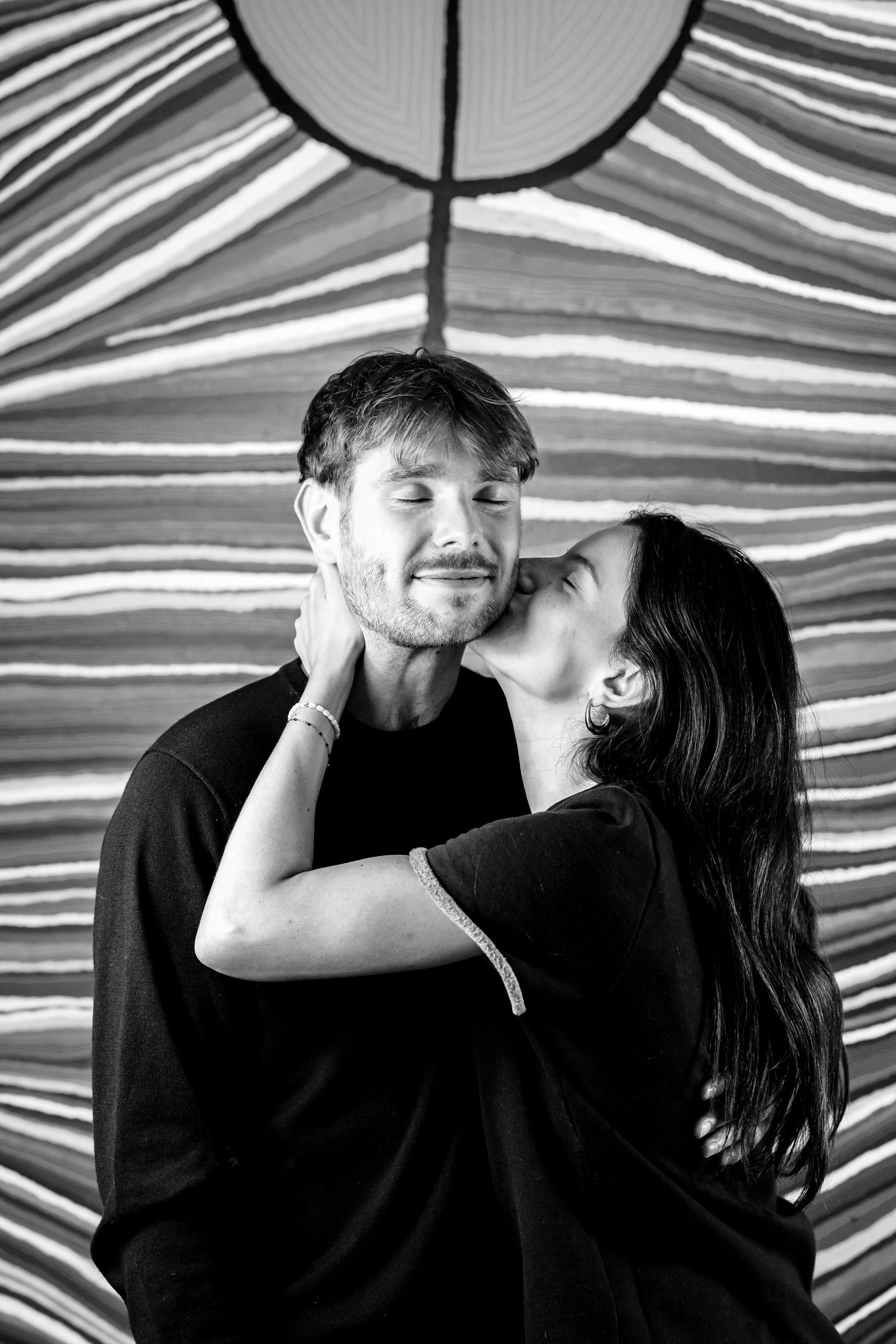Photo de couple bisous sur fond d'un tableau rayé