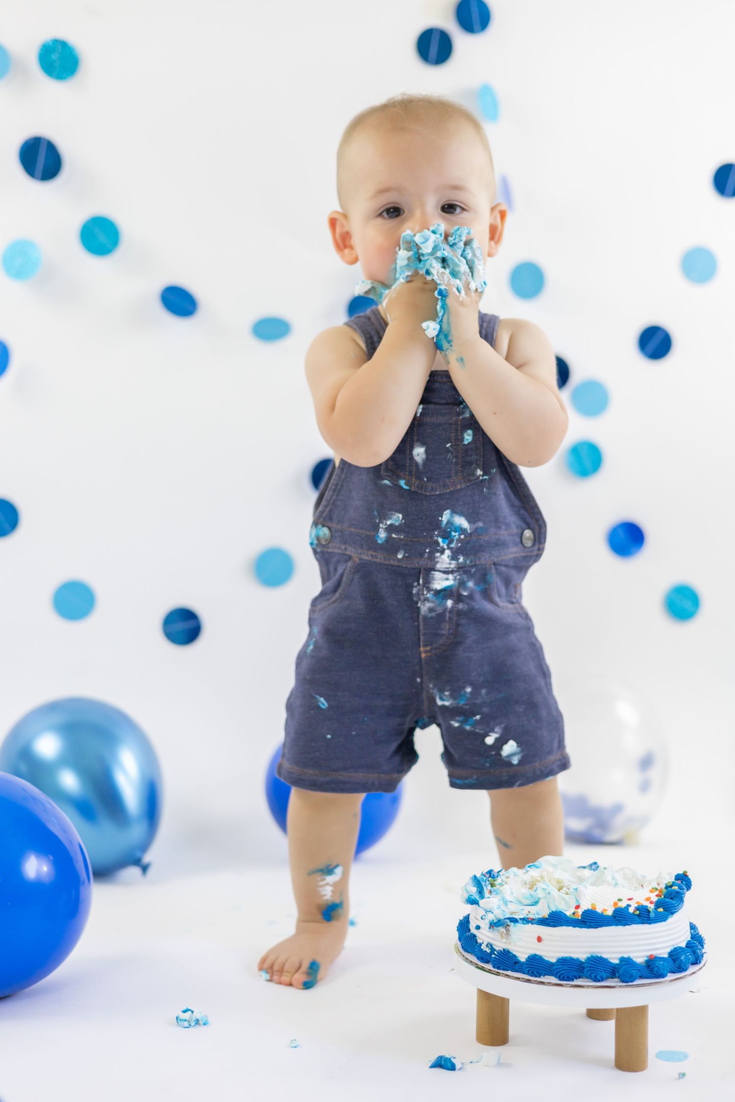 Set of professional cake smash photos with blue balloons, confetti and decorations against white background.