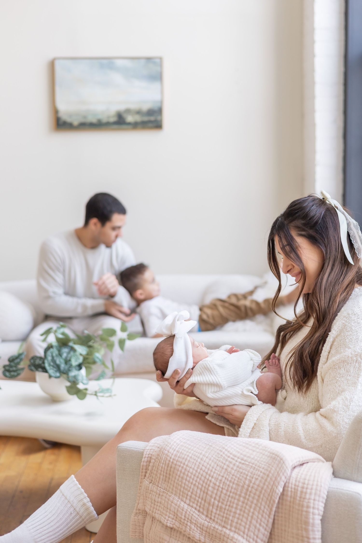 Four cozy lifestyle photos showing people relaxing on a white sofa while using their phones and tablets.