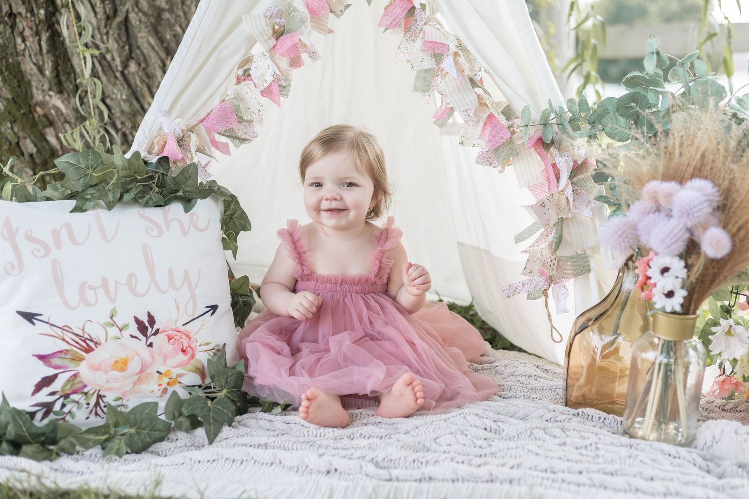 A romantic floral-themed photo session setup with pink dresses, delicate roses, and vintage-inspired decor against a white backdrop.