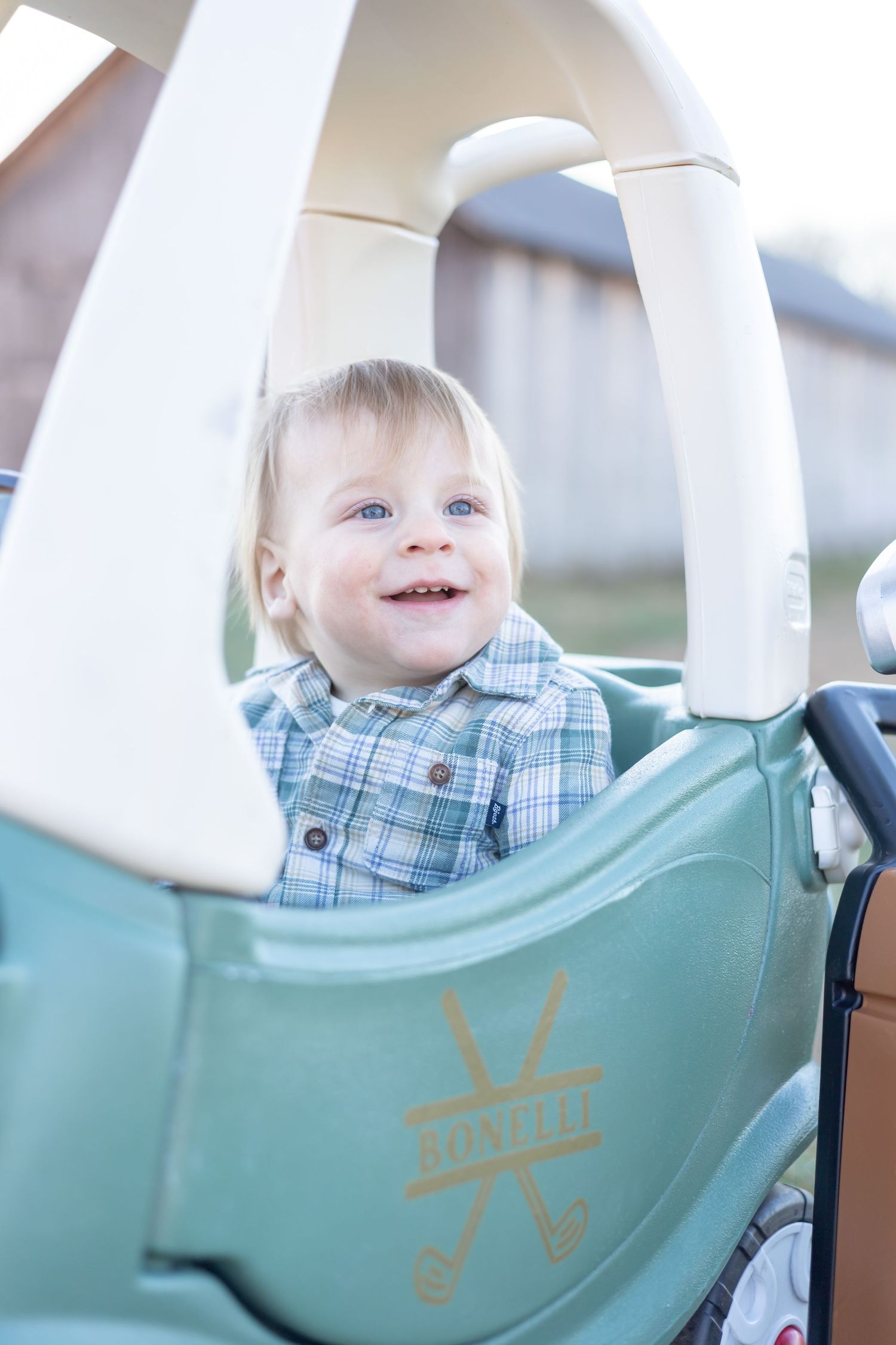 A joyful moment captured in a mint green toy car on a bright sunny day.