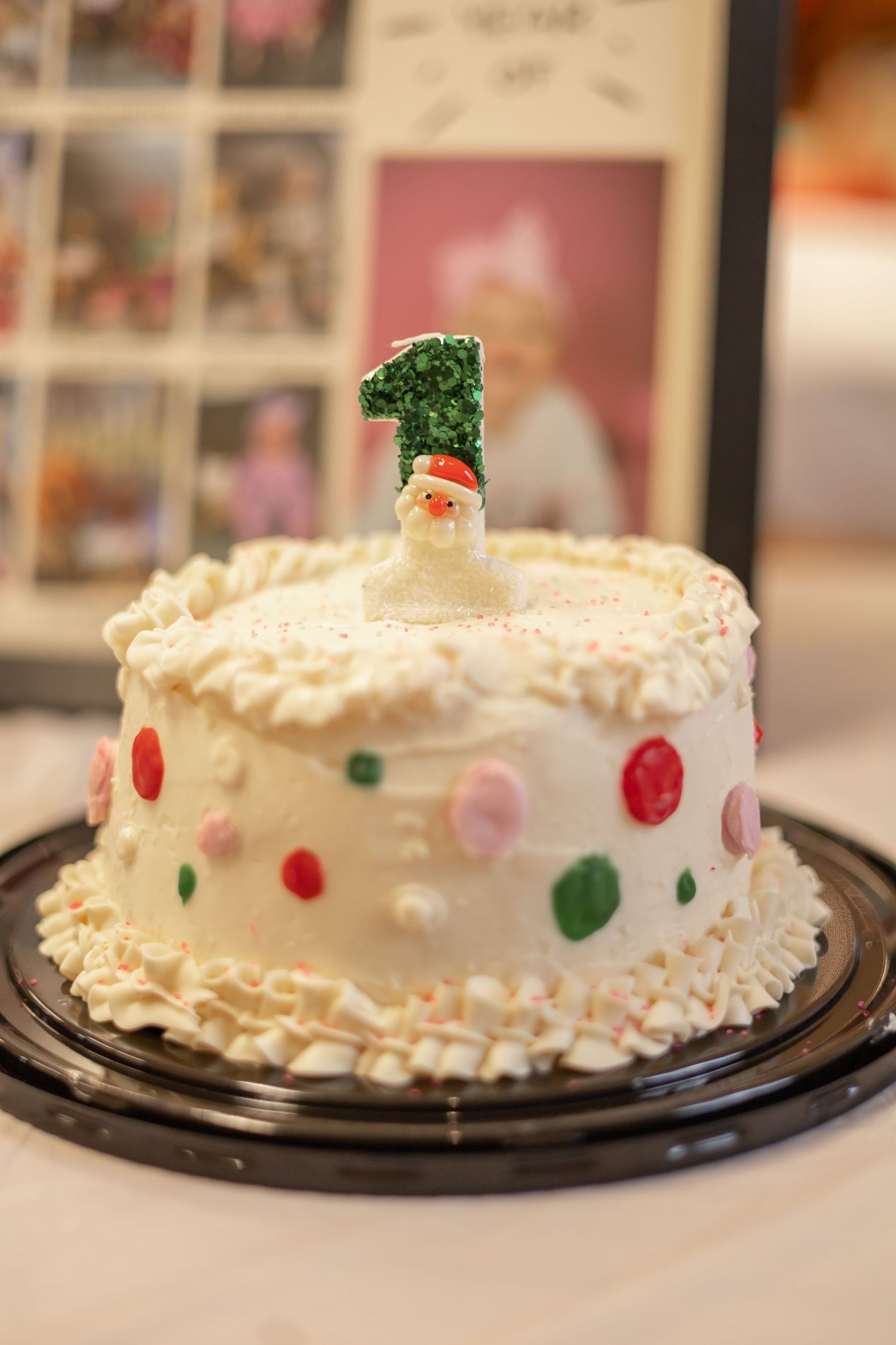 White frosted cake decorated with red and green candies displayed on black plates from multiple angles.