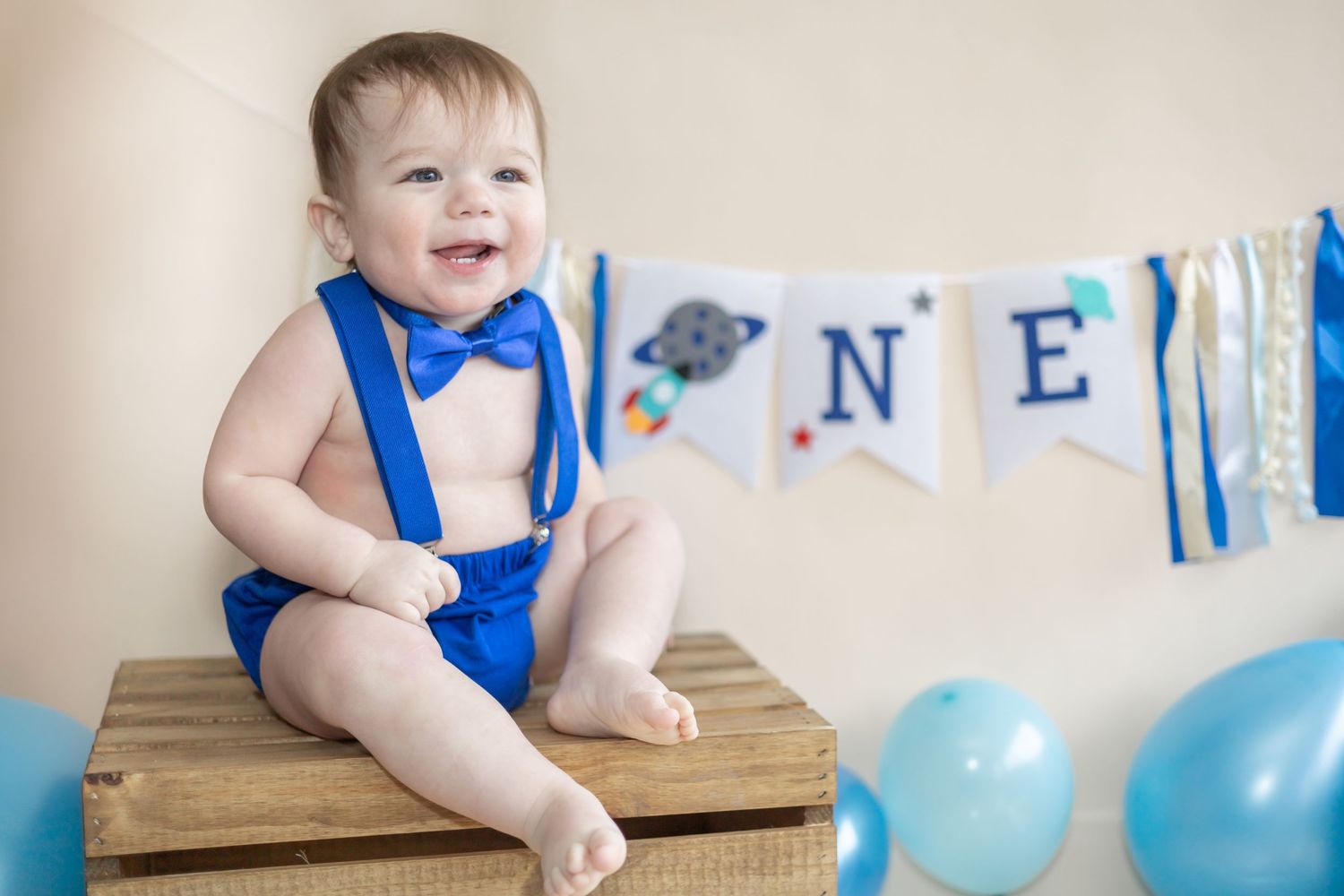 Festive blue and white birthday party setup with balloons and decorative banners for a one year celebration.