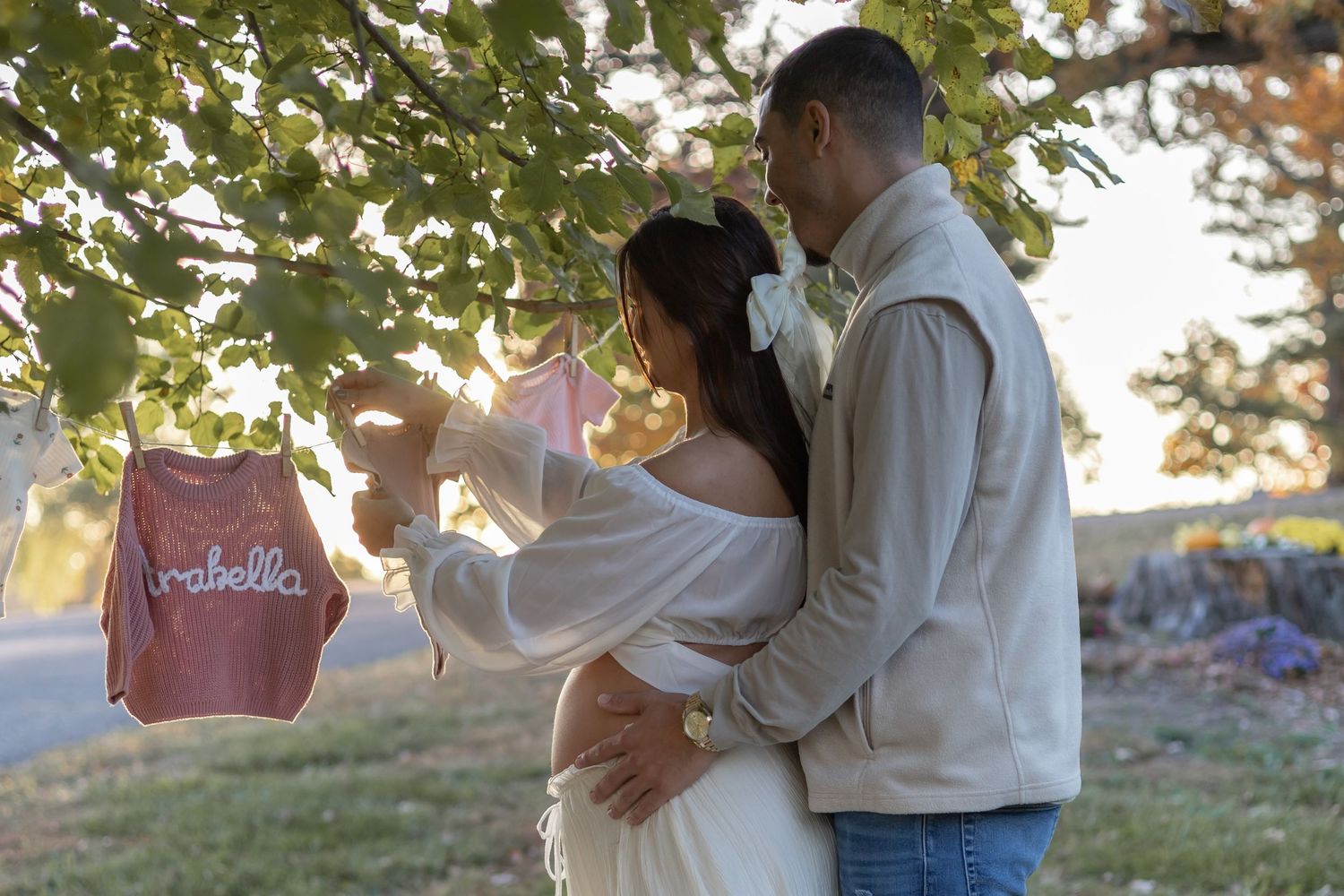 A couple shares a tender embrace outdoors during sunset in a romantic engagement photo session.