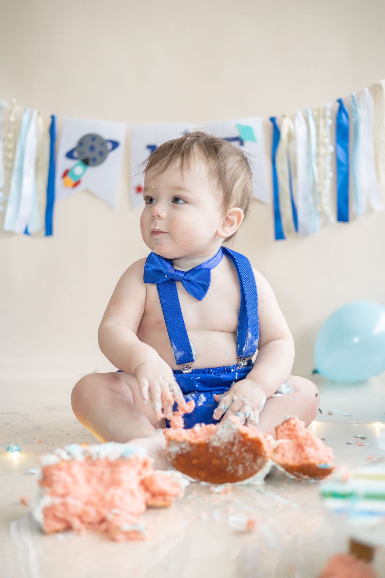 A sequence of cake smash photos shows blue decorations and frosting scattered during joyful first birthday celebrations.