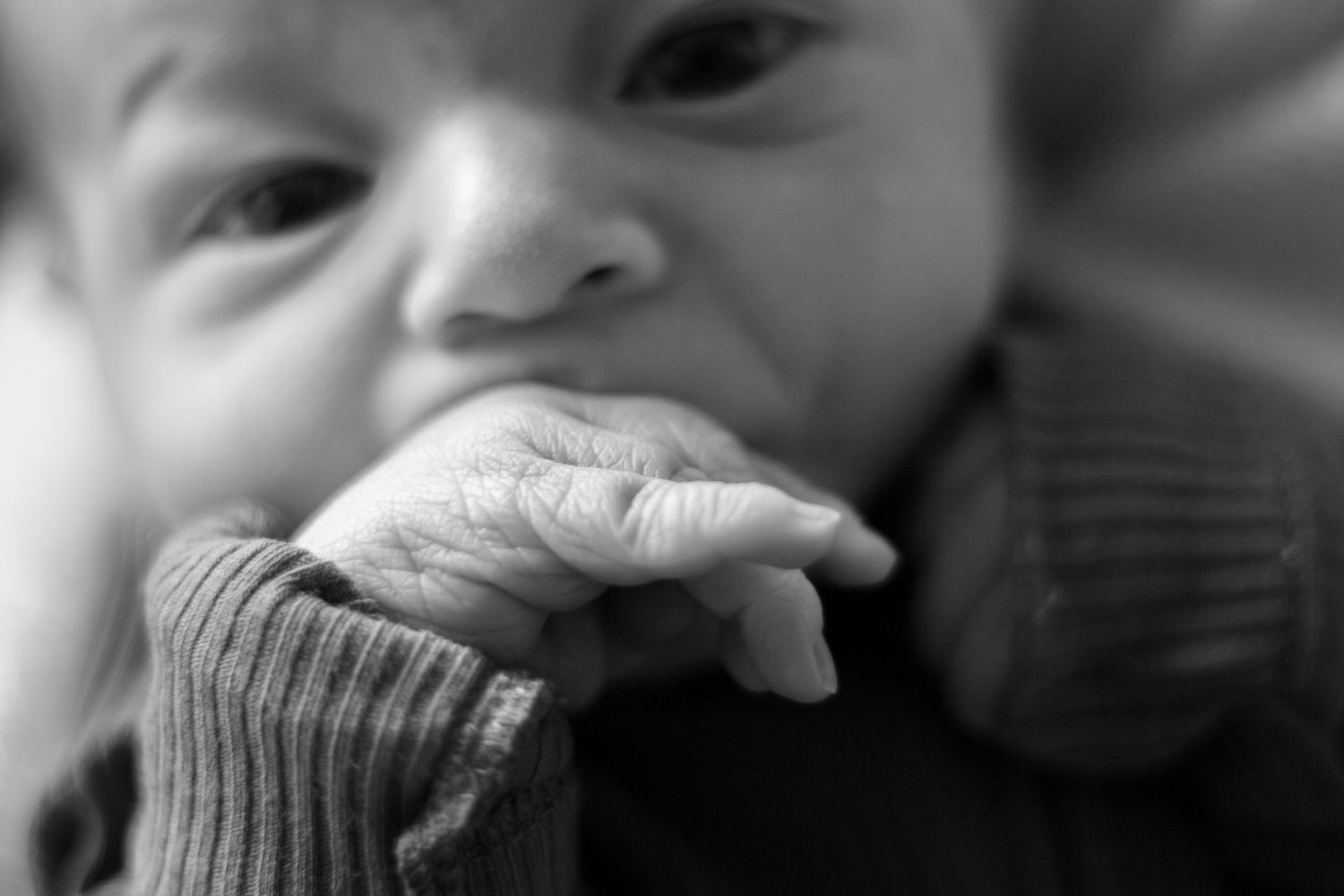 A close-up black and white series showing a baby's various facial expressions and emotions.