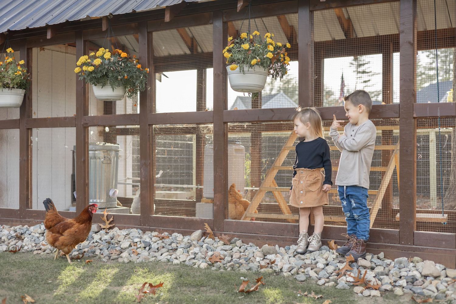 Rustic outdoor venue with wooden beams and hanging yellow flower baskets during a wedding celebration.