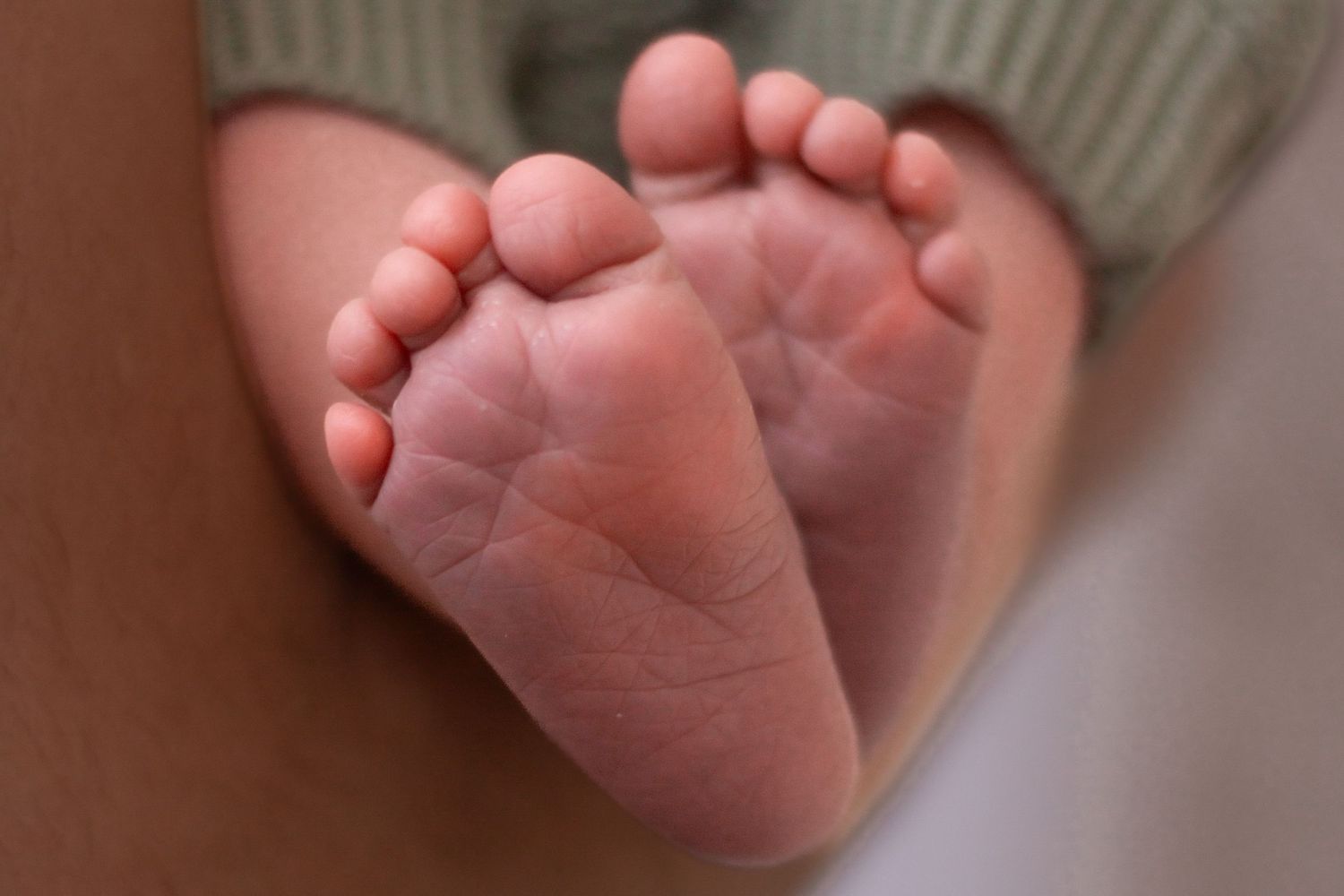 Close-up photo series showing seven different angles of tiny baby feet and toes against a soft pink background.