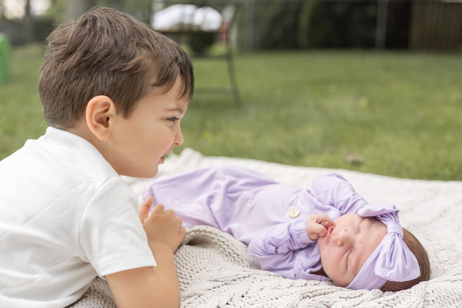 Kids play together under pink petals during spring on a sunny day outdoors.