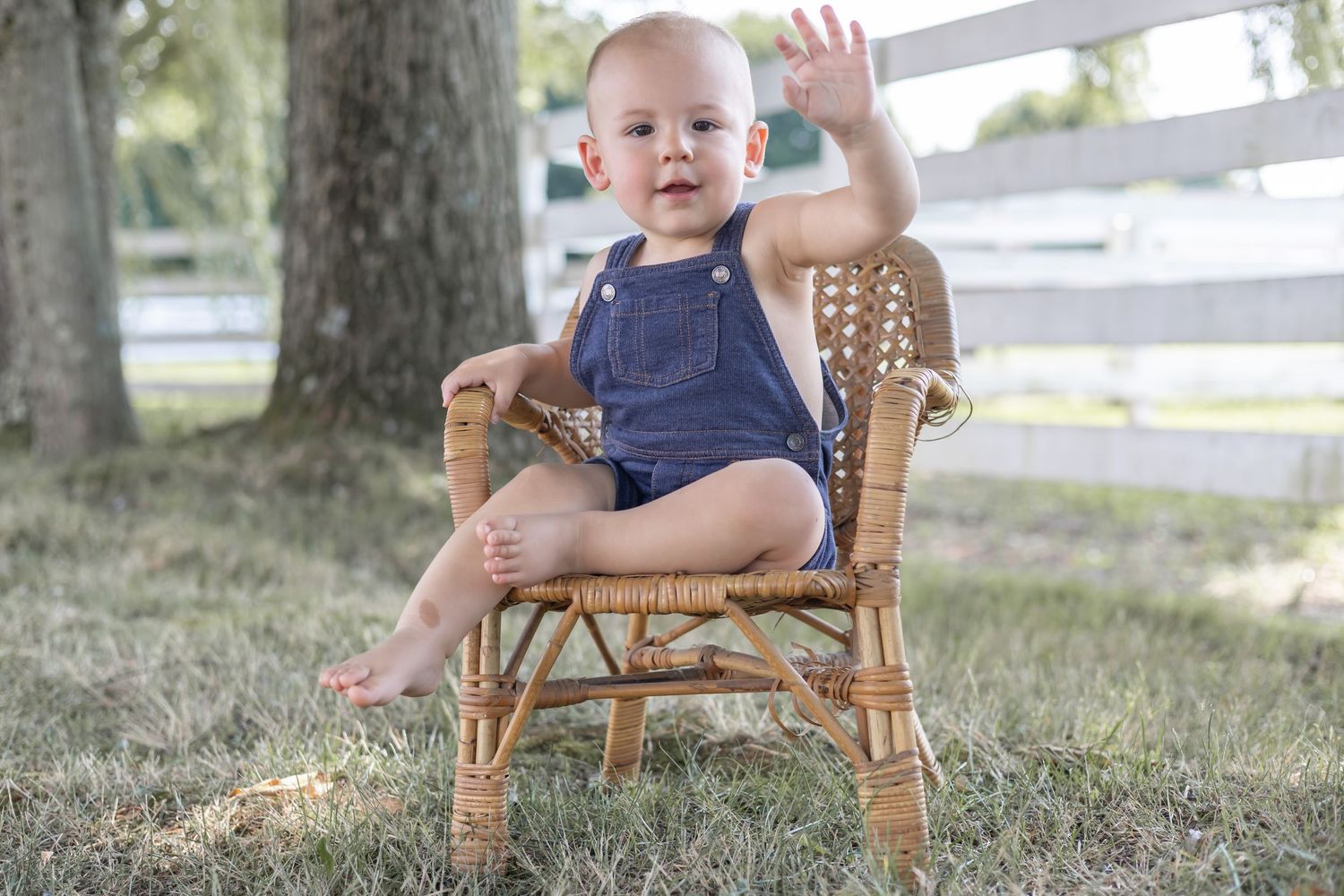 A series of outdoor portraits showing a small child in a wicker chair wearing a navy outfit with white trim in a natural setting.