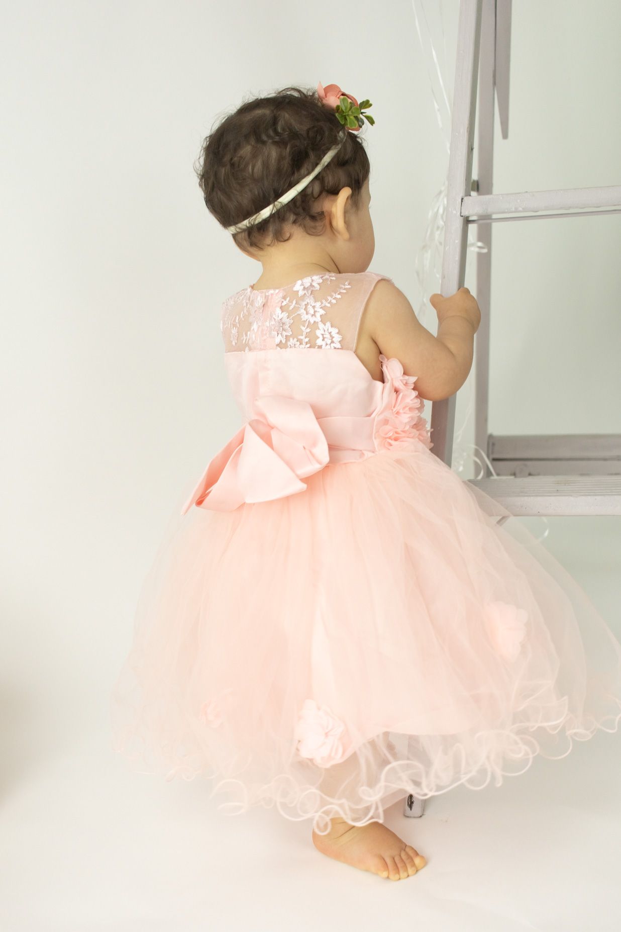 Child in peach tulle dress seen from different angles while playing.
